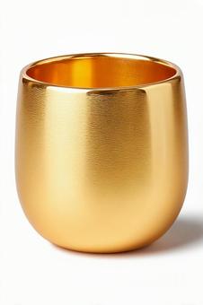 白い背景に立つ金色のタンブラーカップの写真