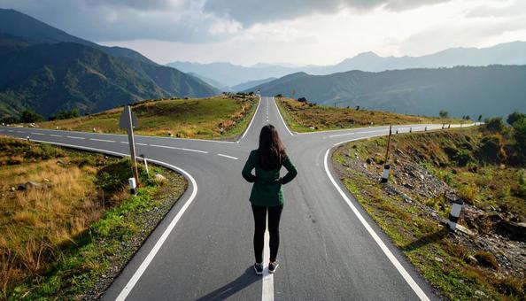 どちらへ進むか考える女性の後ろ姿 どちらへ進むか考える女性の後ろ姿の写真