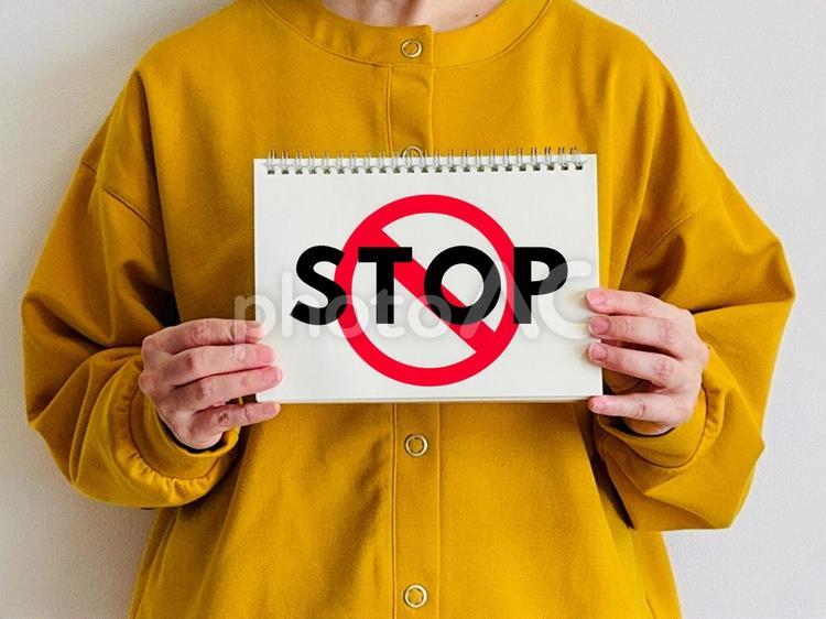 STOPと書かれた標識を持つ女性 ストップ,止まれ,女性の写真素材