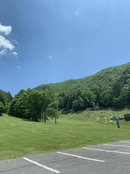 青空広がる山麓と芝生広場の初夏風景 青空,山,芝生の写真素材