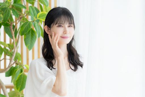 リビングでスキンケアをするミドルの女性 リビングでスキンケアをするミドルの女性 ビューティー,スキンケア,女性の写真素材