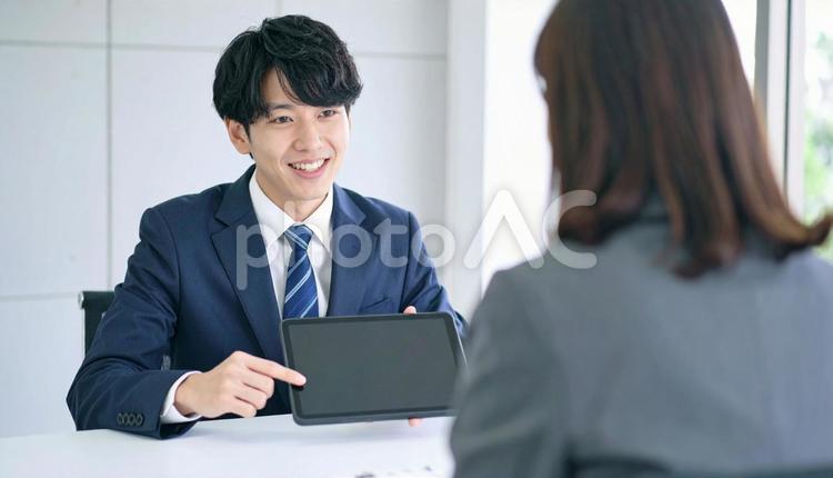 タブレットを使って説明する男性営業マン タブレット,男性営業マン,男性ビジネスマンの写真素材