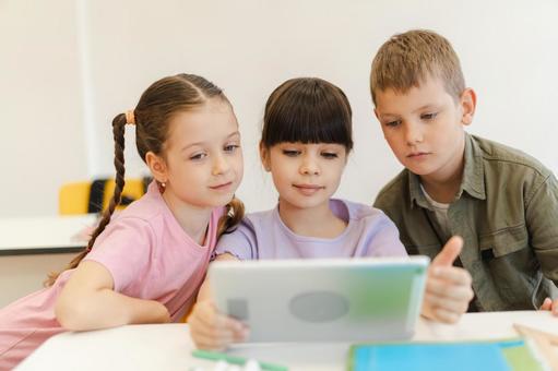 真剣にタブレットを見る生徒たち 男の子,女の子,子どもの写真素材