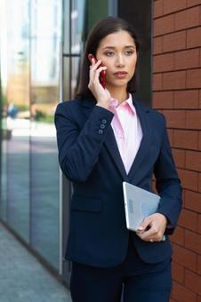 オフィスビルの外で電話するビジネスウーマン ビジネスウーマン,ビジネス,女性の写真素材