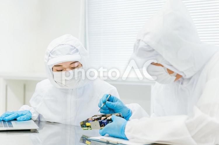 クリーンルームで精密機器を扱う男女 工場,クリーンルーム,製造業の写真素材