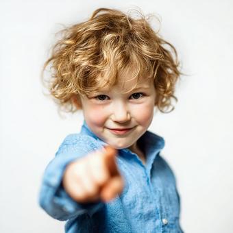 笑顔でこちらを指差す活発な少年 笑顔でこちらを指差す活発な少年の写真