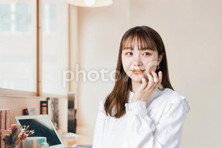 頬に手を当てる笑顔の女性 女性,人物,若いの写真素材