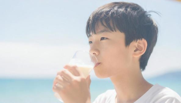 カフェオレを飲む男の子 海 カフェオレを飲む男の子 海の写真