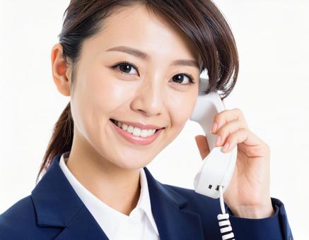 電話の受話器を持って通話している女性 電話の受話器を持って通話している女性の写真