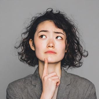 考える20代日本人女性の表情 考える20代日本人女性の表情の写真