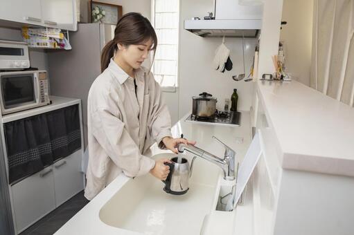 電気ケトルに水を注ぐ女性 女性,キッチン,料理の写真素材