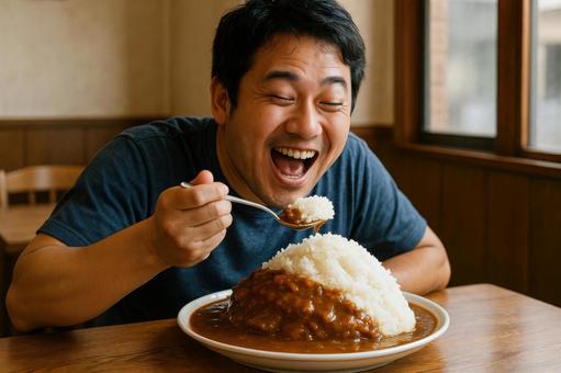 大盛りカレーライスを頬張る日本人男性の写真