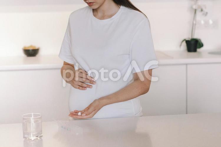 サプリメントを見せる妊婦さんの鼻から下 鼻から下,女性,人物の写真素材