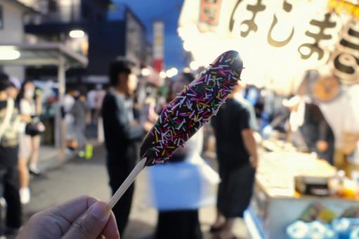 祭りでチョコバナナを持つ女性の手 祭りでチョコバナナを持つ女性の手 チョコバナナ,祭り,屋台の写真素材