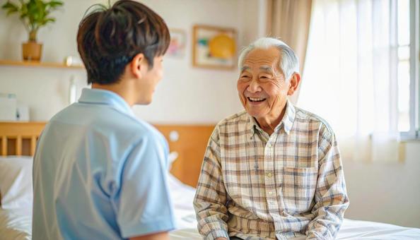 笑顔で話をする男性介護士と高齢男性 笑顔で話をする男性介護士と高齢男性の写真