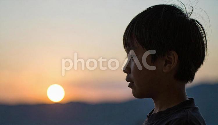 夕焼けの空を見つめる日本人の少年 ビジョン,将来,子供の写真素材