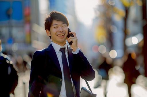 街中を電話をして歩くビジネスマン 街中を電話をして歩くビジネスマンの写真