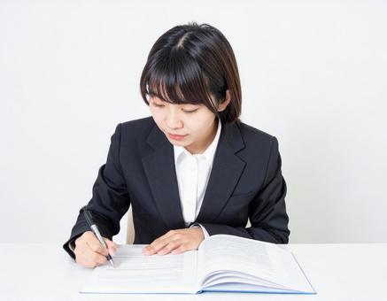 書類を確認するビジネスウーマン 書類を確認するビジネスウーマンの写真