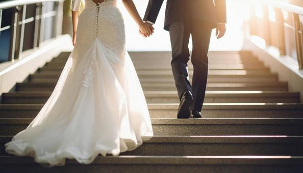 手をつないで階段を上っていく新郎新婦の写真