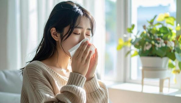 ティッシュで鼻をかむ日本人の若い女性 ティッシュで鼻をかむ日本人の若い女性の写真