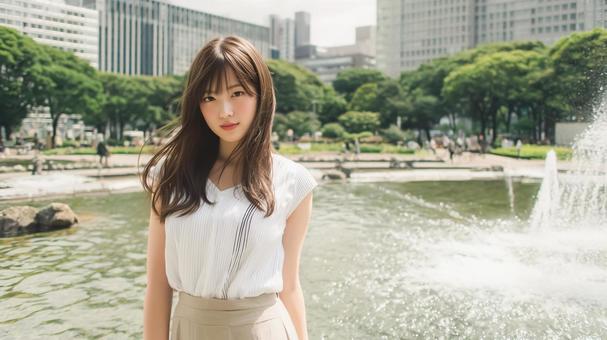 公園の噴水前に立つ女性 公園の噴水前に立つ女性の写真