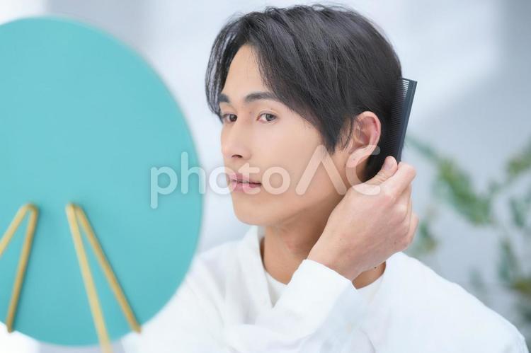 耳の後ろの髪の毛を気にする男性（鏡） 男性,美容男子,化粧男子の写真素材