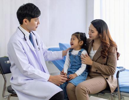 小児科で幼児を診察する医者 小児科で幼児を診察する医者の写真
