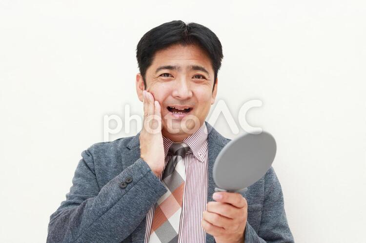 手鏡を持つ笑顔の男性 日本人,男性,人物の写真素材