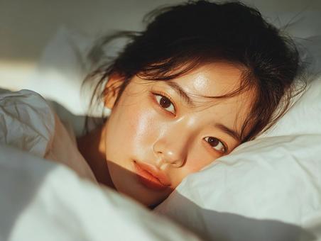 ベッドで目覚める女性の穏やかな朝 ベッドで目覚める女性の穏やかな朝の写真
