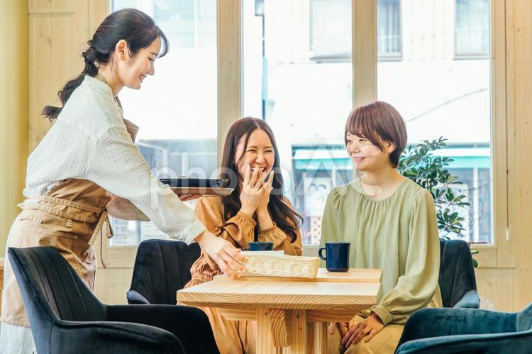 ランチを食べる客とカフェスタッフ ランチ,レストラン,カフェの写真素材