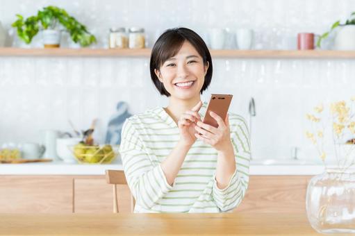 スマホを使う若い女性 スマートフォン,新生活,新居の写真素材