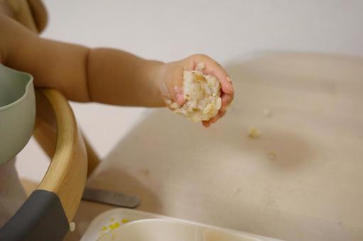 幼児食のおにぎりを掴む子どもの手 手づかみ,子ども,ぐちゃぐちゃの写真素材