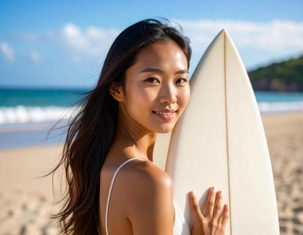 海でサーフボードを持った笑顔の女性 海でサーフボードを持った笑顔の女性の写真