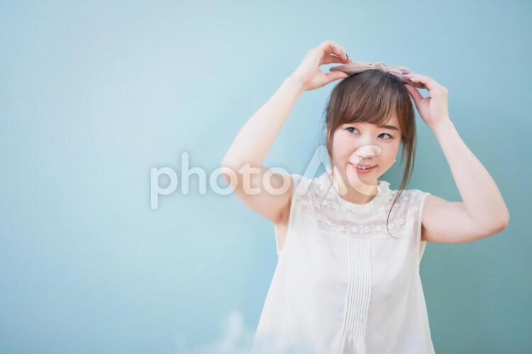 ヘアスタイルを整える女性 ヘアバンド,ターバン,アレンジの写真素材