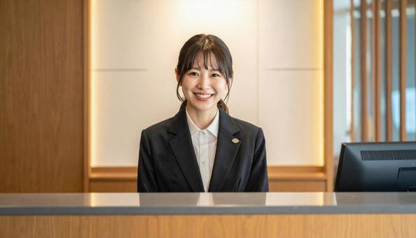 笑顔で対応する女性の受付嬢 笑顔で対応する女性の受付嬢の写真