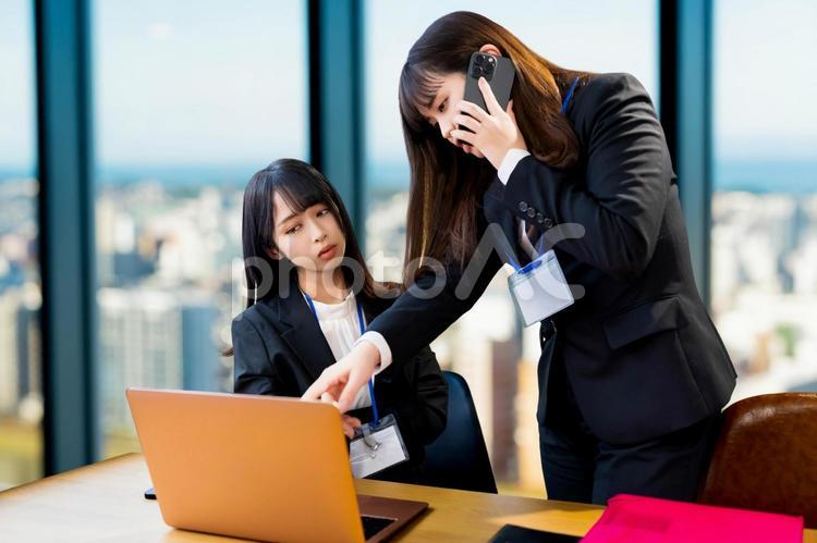電話しながらパソコンを指差す女性会社員 女性,ビジネス,ビジネスウーマンの写真素材