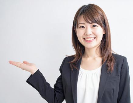 スーツ姿の案内する女性の写真