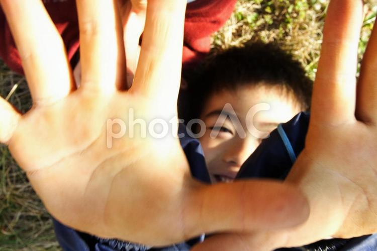 子供が芝生に転んでいる 子供,手のひら,寝転ぶの写真素材
