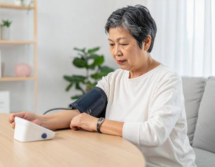 血圧を測り不安そうな表情するシニア女性 血圧を測り不安そうな表情するシニア女性の写真