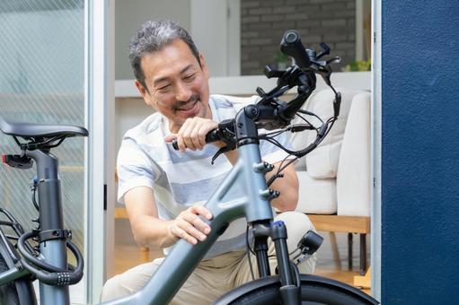 電動自転車をメンテナンスをするミドル男性 電動自転車,男性,ミドルの写真素材