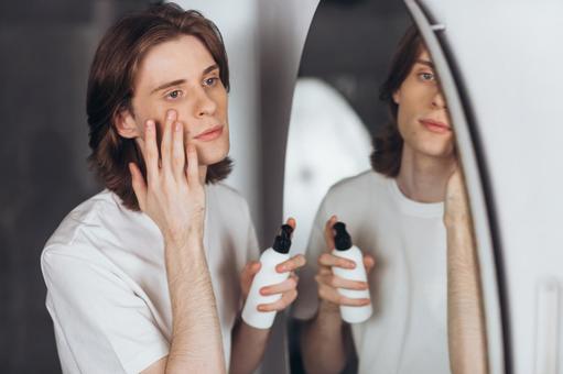 楕円形の鏡の前でスキンケアする男性 男性,外国人,欧米人の写真素材