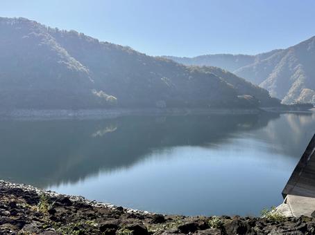 秋の福井県の九頭竜ダム　紅葉に色づく湖の写真