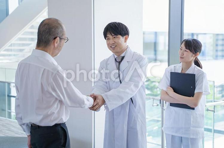 握手する男性医師と看護師と患者 握手,成功,退院の写真素材