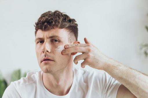 頬に乳液を塗っている男性 男性,外国人,欧米人の写真素材