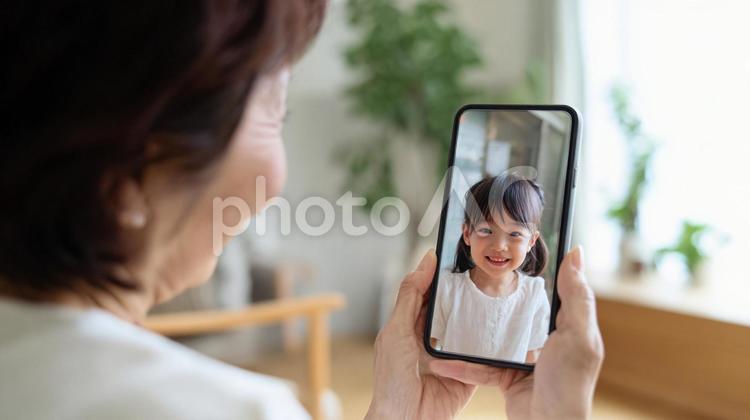 孫とテレビ電話をするおばあちゃん テレビ電話,スマホ,通話の写真素材
