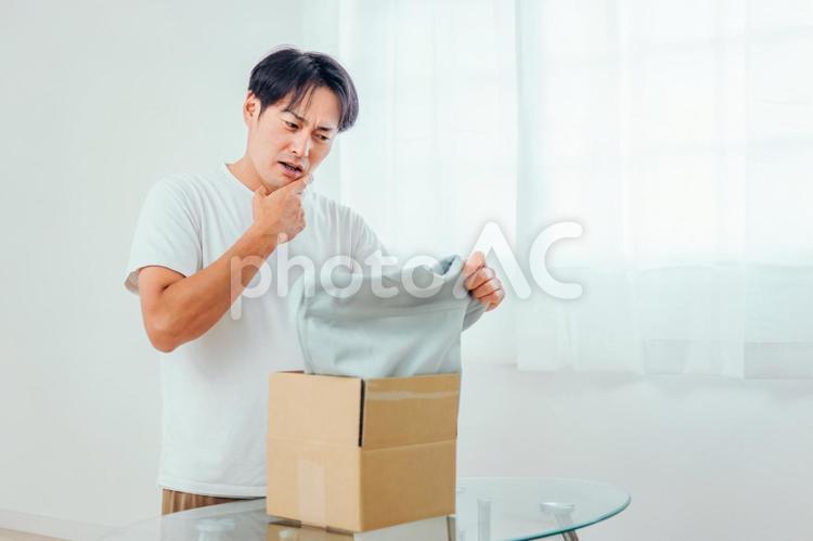 届いた商品に不満な男性（不良品・返品） 不良品,返品,クーリングオフの写真素材