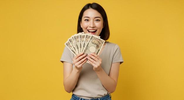 お札を手にして喜ぶ女性 お札を手にして喜ぶ女性の写真