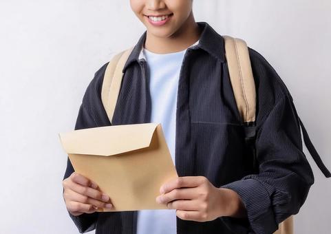 手紙を持った笑顔の男子学生 手紙を持った笑顔の男子学生の写真