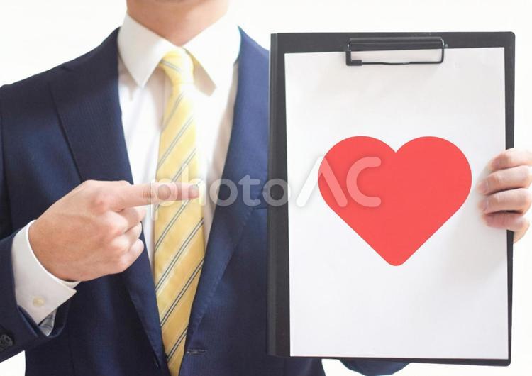 バインダーを指差すビジネスマンとハート ビジネスマン,会社員,男性の写真素材