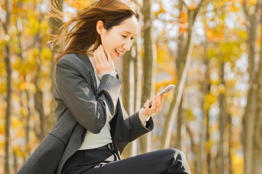 紅葉の街路樹と女性・ビジネスウーマン 女性,秋,紅葉の写真素材